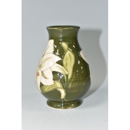 392 - A MOORCROFT POTTERY BALUSTER VASE DECORATED WITH WHITE LILIES ON A GREEN GROUND, impressed marks and... 