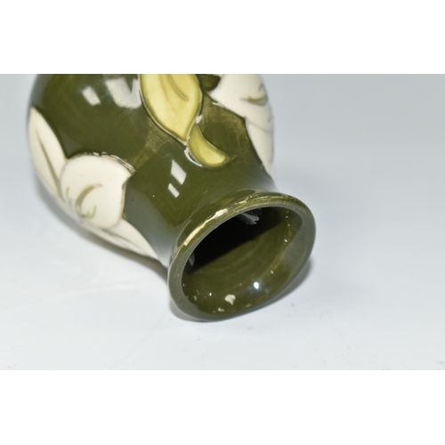 392 - A MOORCROFT POTTERY BALUSTER VASE DECORATED WITH WHITE LILIES ON A GREEN GROUND, impressed marks and... 