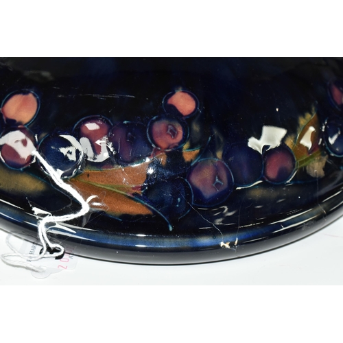 394 - A WILLIAM MOORCROFT SHALLOW FRUIT BOWL DECORATED WITH THE POMEGRANATE PATTERN ON A BLUE / BROWN GREE... 