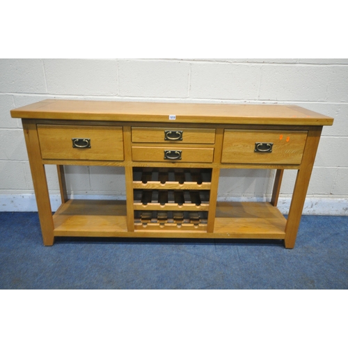 1210 - A SOLID OAK SIDEBOARD, fitted with an arrangement of four drawers and a central three tier wine rack... 