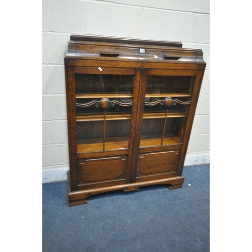 1226 - AN EARLY 20TH CENTURY OAK BOOKCASE, with two drawers, above two glazed doors, enclosing three adjust... 