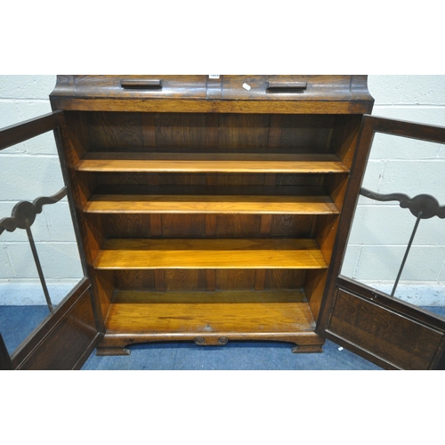 1226 - AN EARLY 20TH CENTURY OAK BOOKCASE, with two drawers, above two glazed doors, enclosing three adjust... 