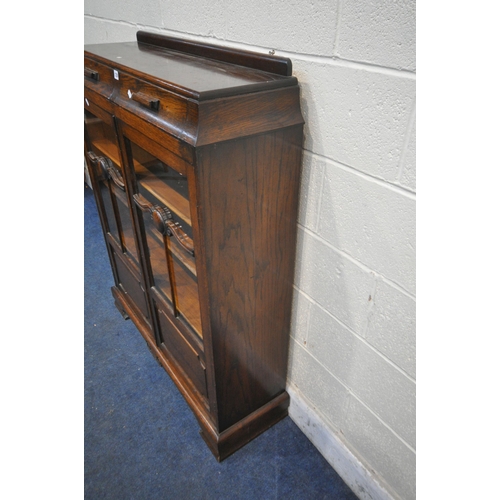 1226 - AN EARLY 20TH CENTURY OAK BOOKCASE, with two drawers, above two glazed doors, enclosing three adjust... 