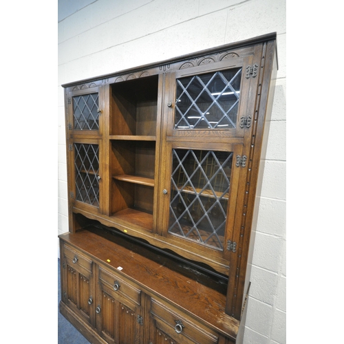 1243 - A 20TH CENTURY OAK DRESSER, the top fitted with an arrangement of lead glazed doors and shelving, th... 