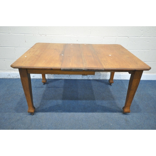 1261 - AN ARTS AND CRAFTS OAK WIND OUT DINING TABLE, with two additional leaves and one winding handle, on ... 