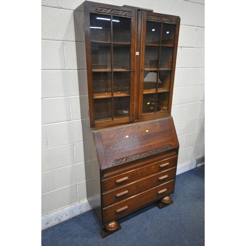 1263 - A 20TH CENTURY OAK BUREAU BOOKCASE, the top with double glazed doors, enclosing three adjustable she... 