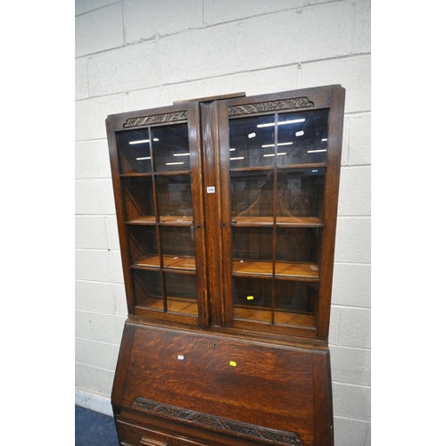 1263 - A 20TH CENTURY OAK BUREAU BOOKCASE, the top with double glazed doors, enclosing three adjustable she... 