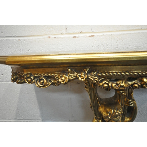 1271 - A REPRODUCTION ROCOCO STYLE GILT CONSOLE TABLE, with a glass insert, floral decoration, scantily cla... 