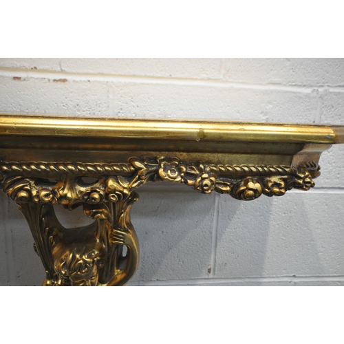 1271 - A REPRODUCTION ROCOCO STYLE GILT CONSOLE TABLE, with a glass insert, floral decoration, scantily cla... 