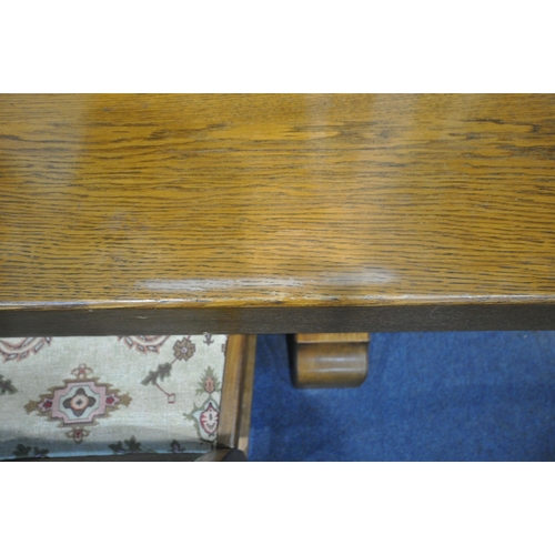 1283 - A SOLID OAK RECTANGULAR DINING TABLE, with two additional leaves, on trestle legs, united by a block... 