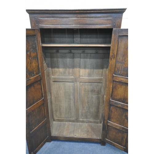 1292 - A REPRODUCTION SOLID OAK HALL ROBE, with double panelled doors, enclosing a single shelf and four co... 