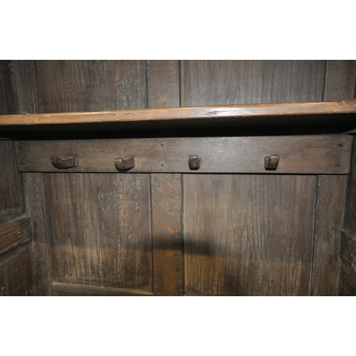 1292 - A REPRODUCTION SOLID OAK HALL ROBE, with double panelled doors, enclosing a single shelf and four co... 