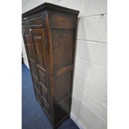 1292 - A REPRODUCTION SOLID OAK HALL ROBE, with double panelled doors, enclosing a single shelf and four co... 