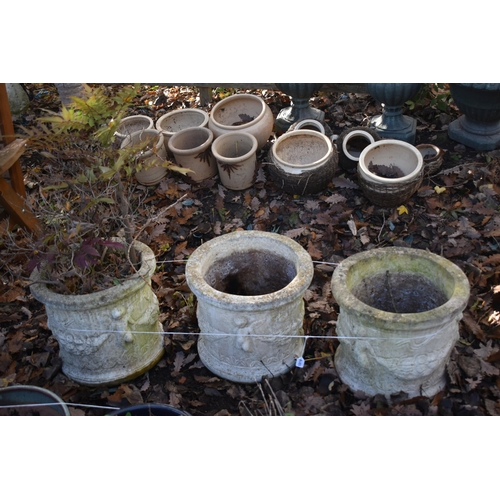 1019 - A SET OF THREE WEATHERED COMPOSITE PLANTERS, with cherubs to the side, diameter 44cm x height 39cm (... 