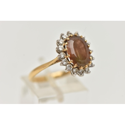 19 - AN 18CT GOLD SMOKY QUARTZ AND DIAMOND CLUSTER RING, the oval smoky quartz within a brilliant cut dia... 