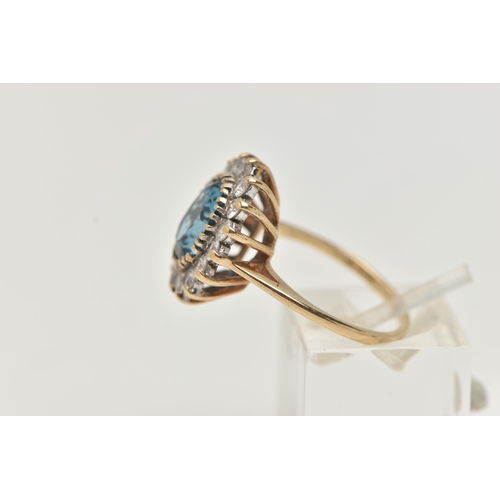 49 - A 9CT GOLD CLUSTER RING, centring on an oval cut blue topaz, in a surround of colourless cubic zirco... 