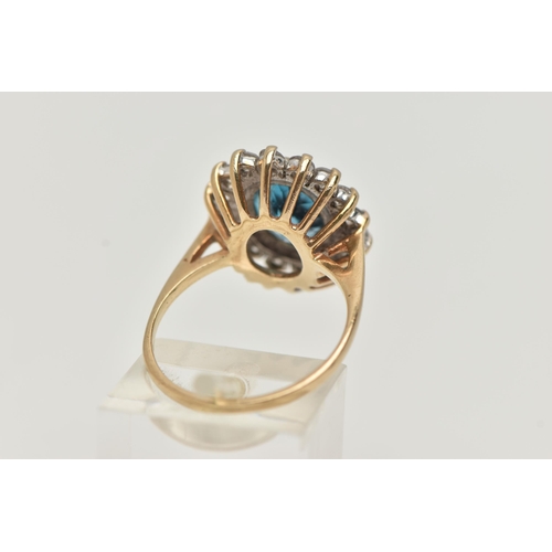 49 - A 9CT GOLD CLUSTER RING, centring on an oval cut blue topaz, in a surround of colourless cubic zirco... 