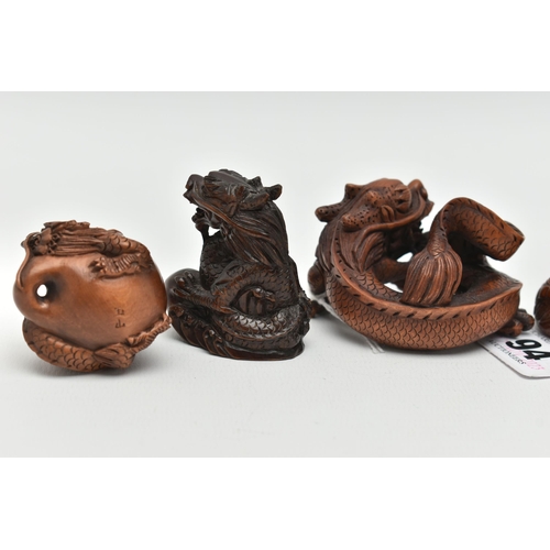 94 - FOUR 20TH CENTURY CARVED TREEN NETSUKE AND TWO OKIMONO, all in the form of dragons, all with inset e... 