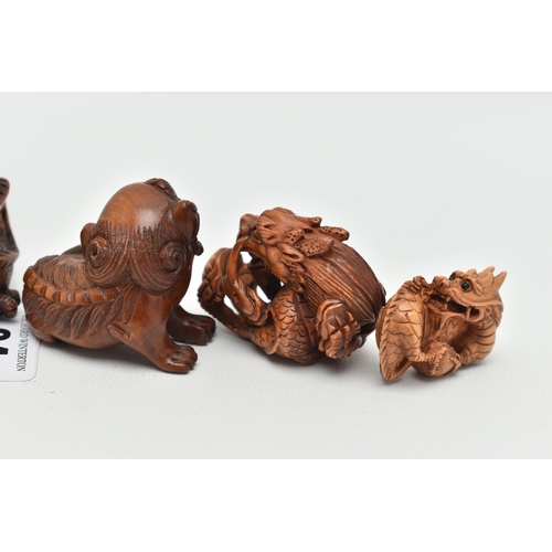 94 - FOUR 20TH CENTURY CARVED TREEN NETSUKE AND TWO OKIMONO, all in the form of dragons, all with inset e... 