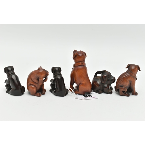 95 - FOUR 20TH CENTURY CARVED TREEN NETSUKE AND TWO OKIMONO, all in the form of dogs, five with inset eye... 