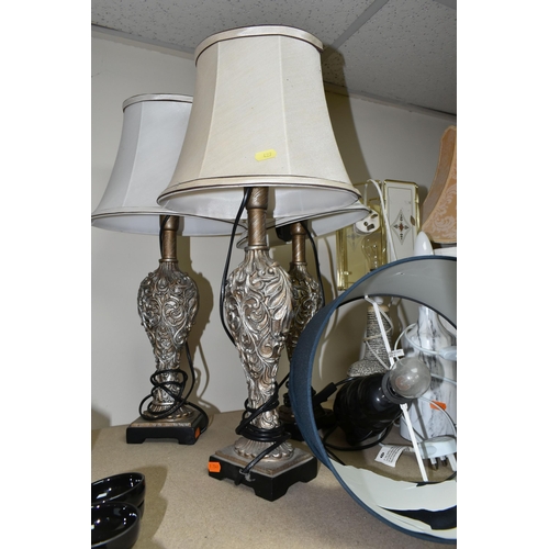 427 - A GROUP OF TABLE LAMPS, comprising three matching silver coloured foliate lamps, a novelty Elvis lam... 