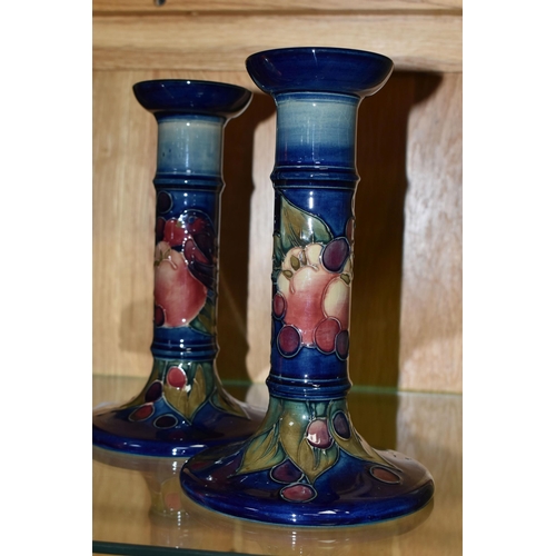 497 - A PAIR OF MODERN MOORCROFT POTTERY CANDLESTICKS DECORATED WITH FINCHES AND FRUIT, painted and impres... 