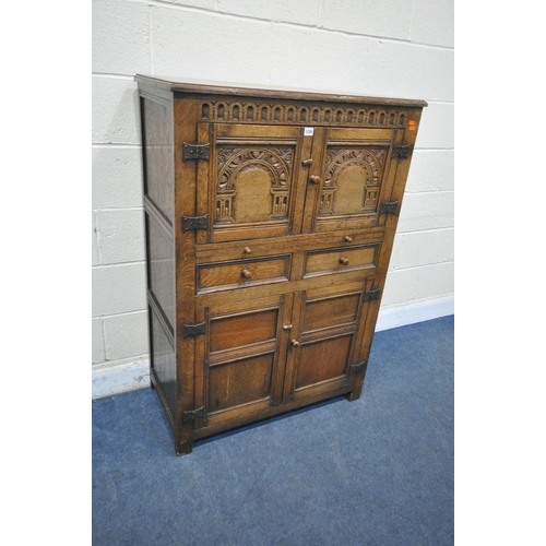 1209 - A 20TH CENTURY SOLID OAK CABINET, fitted with two cupboard doors, carved with an archway, a brushing... 