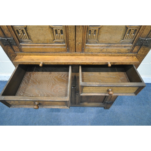 1209 - A 20TH CENTURY SOLID OAK CABINET, fitted with two cupboard doors, carved with an archway, a brushing... 