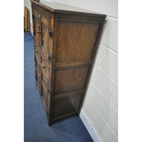 1209 - A 20TH CENTURY SOLID OAK CABINET, fitted with two cupboard doors, carved with an archway, a brushing... 