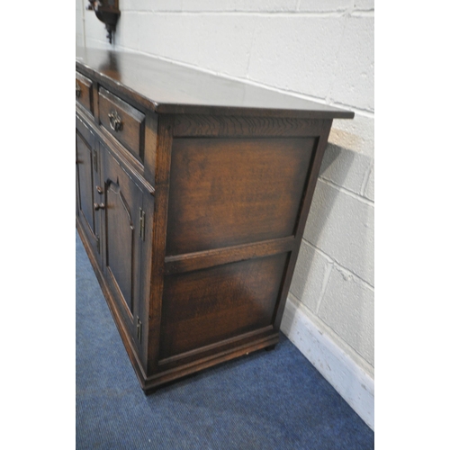 1210 - IN THE MANNER OF TITCHMARSH AND GOODWIN, A SOLID OAK SIDEBOARD, with three drawers above three cupbo... 