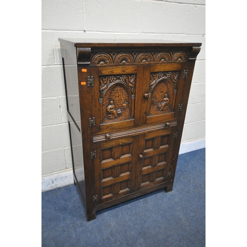 1211 - A 20TH CENTURY SOLID OAK DRINKS CABINET, the two double doors , carved with a seated person, an arch... 