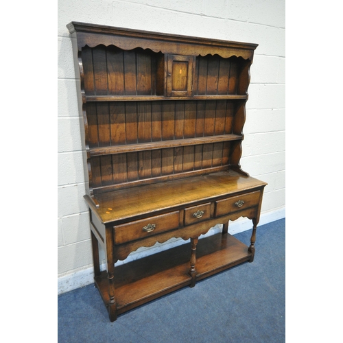 1212 - IN THE MANNER OF TITCHMARSH AND GOODWIN, A SOLID OAK DRESSER, the top fitted with an arrangement of ... 