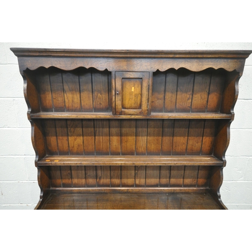 1212 - IN THE MANNER OF TITCHMARSH AND GOODWIN, A SOLID OAK DRESSER, the top fitted with an arrangement of ... 