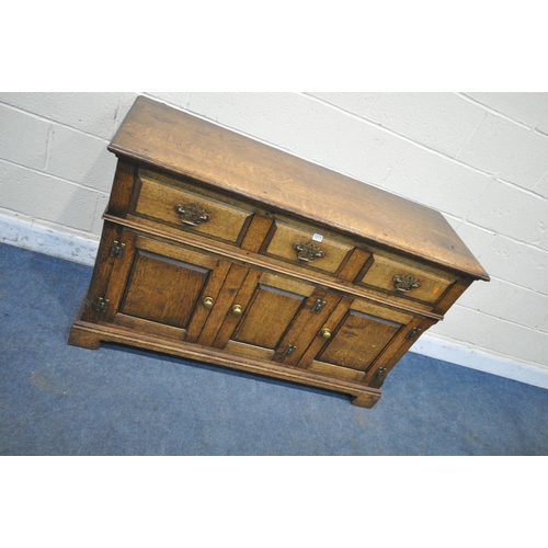 1213 - IN THE MANNER OF TITCHMARSH AND GOODWIN, A SOLID OAK SIDEBOARD, with three drawers over three cupboa... 