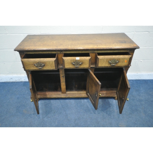 1213 - IN THE MANNER OF TITCHMARSH AND GOODWIN, A SOLID OAK SIDEBOARD, with three drawers over three cupboa... 