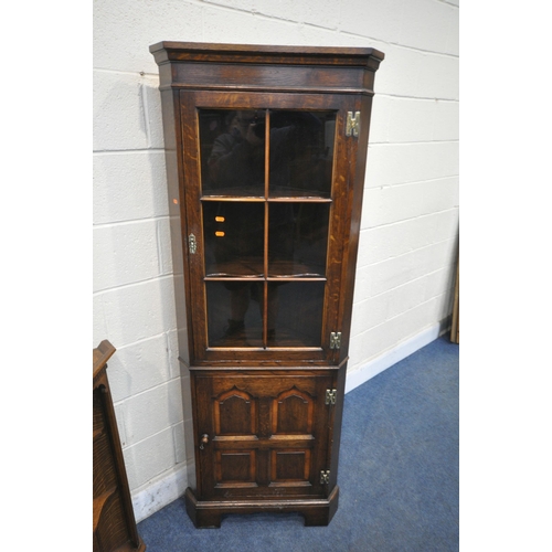 1216 - IN THE MANNER OF TITCHMARSH AND GOODWIN, A SOLID OAK CORNER CUPBOARD, with a glazed door, above a cu... 