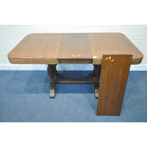 1218 - A WARING AND GILLOW OAK DRAW LEAF TABLE, with two additional leaves, on a pair of twin acorn support... 