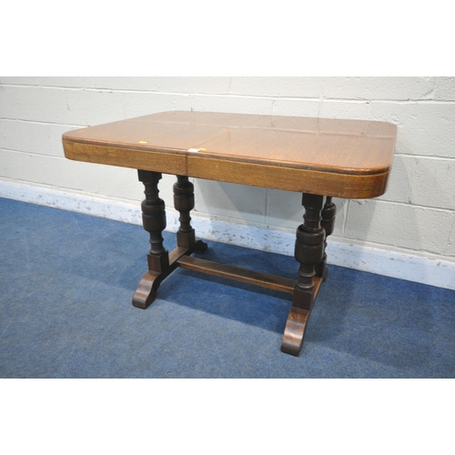 1218 - A WARING AND GILLOW OAK DRAW LEAF TABLE, with two additional leaves, on a pair of twin acorn support... 