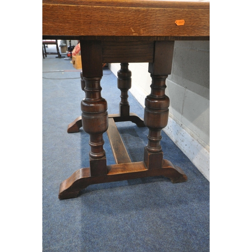 1218 - A WARING AND GILLOW OAK DRAW LEAF TABLE, with two additional leaves, on a pair of twin acorn support... 