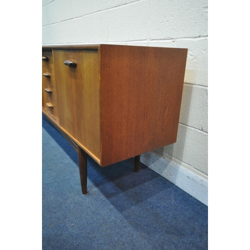 1251 - A MID CENTURY TEAK G PLAN SIDEBOARD, fitted with double cupboard doors, four recessed drawers, top d... 