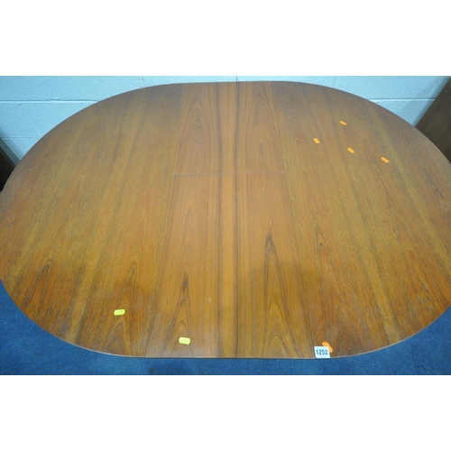 1252 - A MID CENTURY TEAK EXTENDING DINING TABLE, with a single fold out leaf, on cylindrical tapered legs,... 