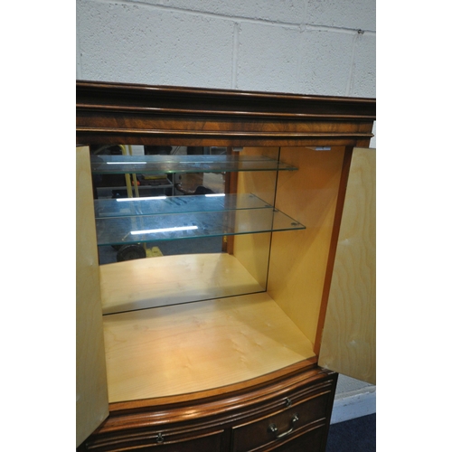 1258 - A REPRODUX FLAME MAHOGANY SERPENTINE COCKTAIL CABINET, fitted with four cupboard doors, a brushing s... 