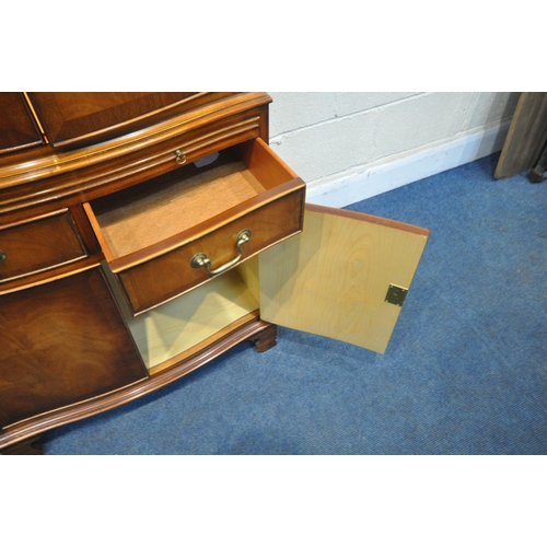 1258 - A REPRODUX FLAME MAHOGANY SERPENTINE COCKTAIL CABINET, fitted with four cupboard doors, a brushing s... 