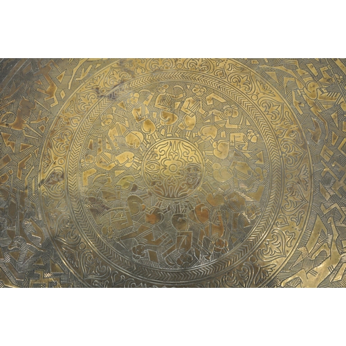 1268 - A CIRCULAR BRASS TOP FOLDING TABLE, the top depicting hunting scenes, etc., on a folding barley twis... 