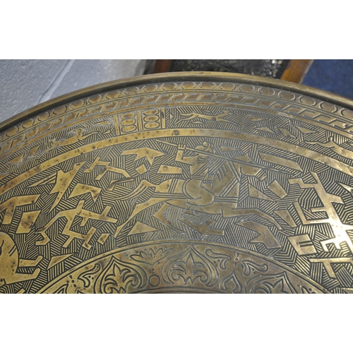 1268 - A CIRCULAR BRASS TOP FOLDING TABLE, the top depicting hunting scenes, etc., on a folding barley twis... 