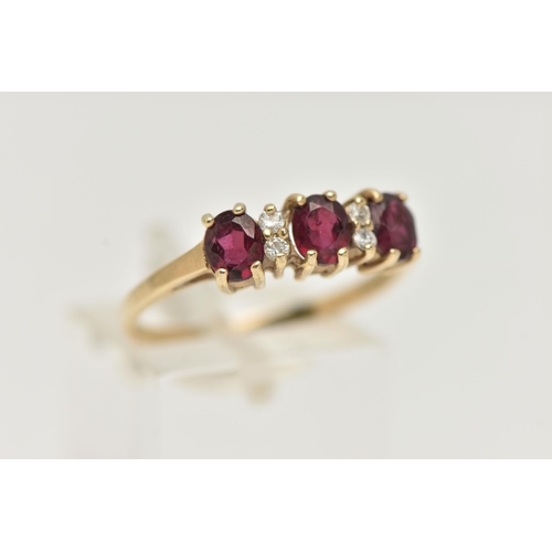 48 - A 9CT GOLD GARNET AND DIAMOND RING, with three oval cut garnets, each four claw set, interspaced wit... 