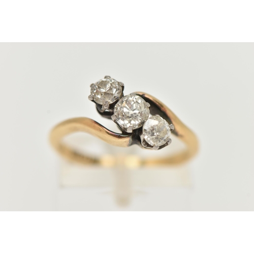 66 - A YELLOW METAL THREE STONE DIAMOND RING, cross over design, set with three old cut diamonds, estimat... 