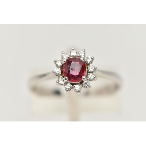 93 - A RUBY AND DIAMOND RING, circular cut ruby prong set in white metal, with a surround of twelve round... 