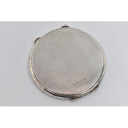 145 - A SILVER COMPACT, of circular outline with engine turned decoration and central banded detail with e... 