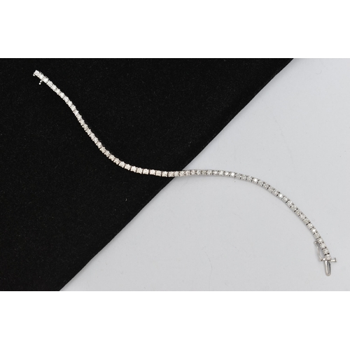 150 - A 9CT WHITE GOLD DIAMOND LINE BRACELET, designed as sixty-four round brilliant cut diamonds each wit... 